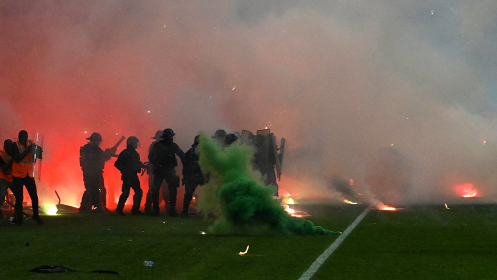 TOPSHOT - Riot police officers clash with Saint-Etienne's fans who invaded the pitch after being defeated by Auxerre at the end of the French L1-L2 play-off second leg football match between AS Saint-Etienne and AJ Auxerre at the Geoffroy Guichard Stadium in Saint-Etienne, central-eastern France on May 29, 2022. (Photo by JEAN-PHILIPPE KSIAZEK / AFP) (Photo by JEAN-PHILIPPE KSIAZEK/AFP via Getty Images)