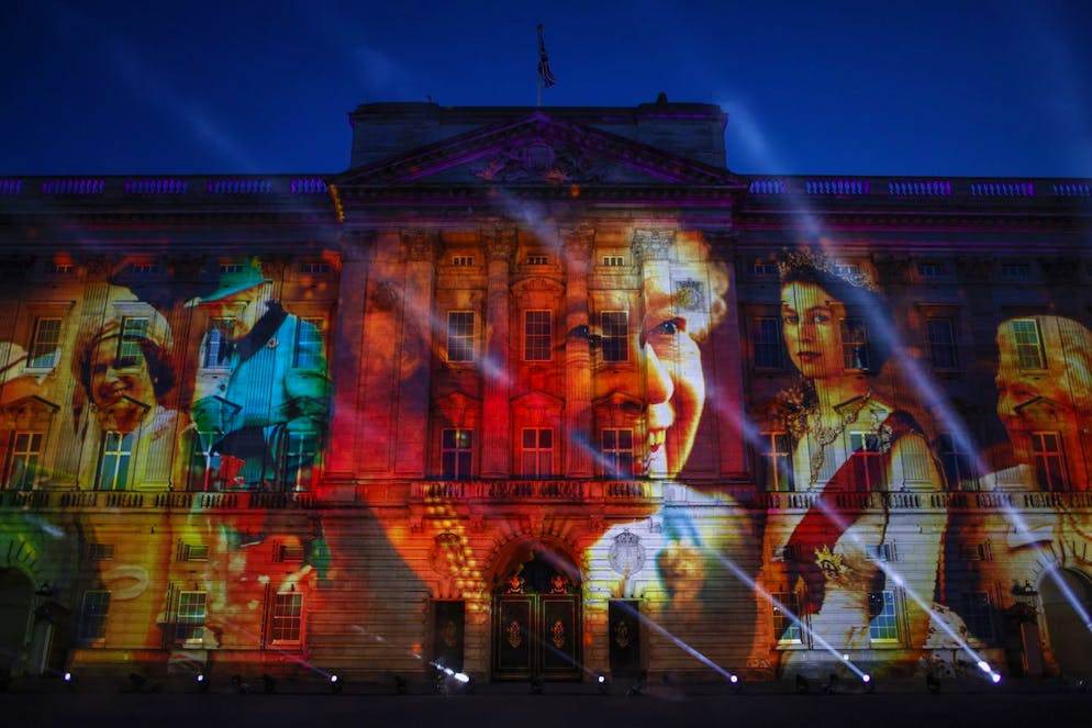 Images of Queen Elizabeth II are projected onto the facade of Buckingham Palace at the end of the first day of the Platinum Jubilee in London, Thursday June 2, 2022. The events over a long holiday weekend in the U.K. are meant to celebrate the monarch's 70 years of service. (AP Photo/David Cliff)