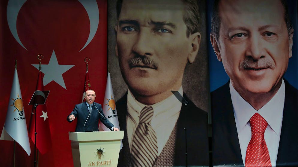 Backdropped by pictures of himself, right, and modern Turkey's founder Mustafa Kemal Ataturk, centre, Turkey's President Recep Tayyip Erdogan addresses officials of his ruling Justice and Development Party (AKP), in Ankara, Turkey, Friday, Sept. 14, 2018. Erdogan has reproached Turkey's central bank's move to sharply raise interest rates on Thursday from 17.75 percent to 24 percent to stem a currency crisis. (Presidential Press Service via AP, Pool)