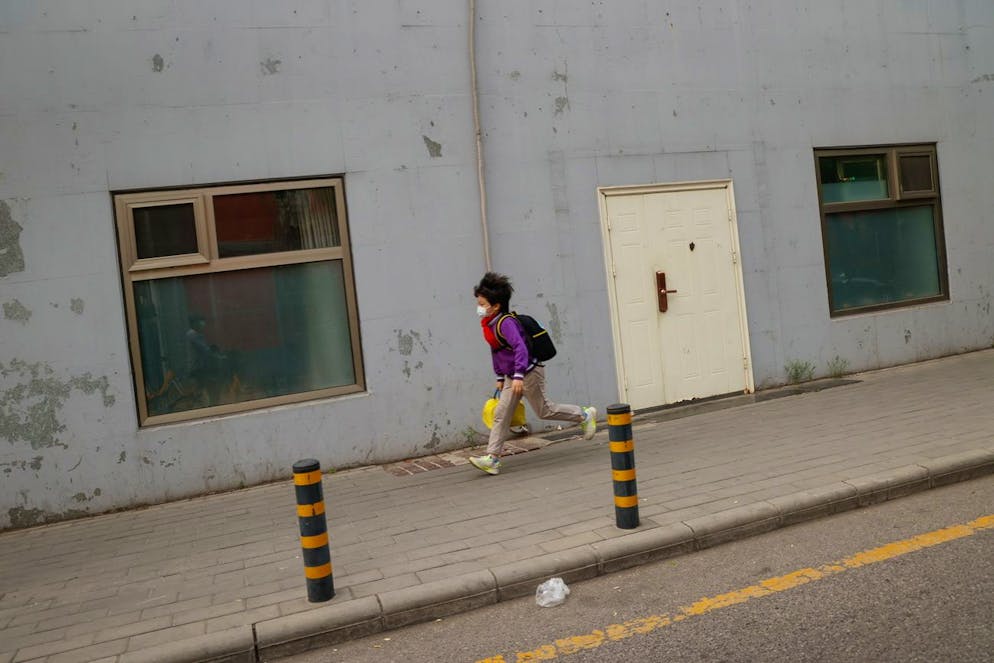 epa09907716 A student runs to school in Beijing, China, 25 April 2022. The city reported 41 new COVID-19 cases among students and tour group senior people in the previous 72 hours, as local health authorities said infection risks remained high with the number of cases expected to increase in the following days. EPA/MARK R. CRISTINO