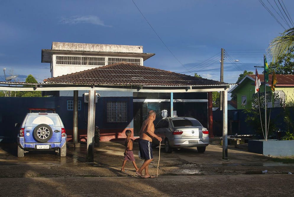 A man and a boy walk past the police station where fisherman Amarildo da Costa de Oliveira is detained, considered a suspect by the police in the disappearance of British journalist Dom Phillips and Indigenous affairs expert Bruno Araujo Pereira in the Javari Valley Indigenous territory, Atalaia do Norte, Amazonas state, Brazil, Friday, June 10, 2022. Phillips and Pereira were last seen on Sunday morning in the Javari Valley, Brazil's second-largest Indigenous territory which sits in an isolated area bordering Peru and Colombia. (AP Photo/Edmar Barros)