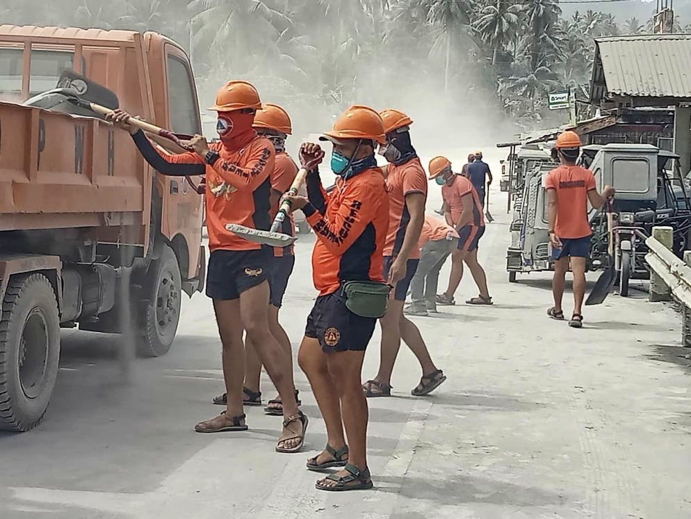 Une photo mise à disposition par la Garde côtière philippine (PCG) montre des intervenants de la PCG menant des opérations de déblayage de routes.