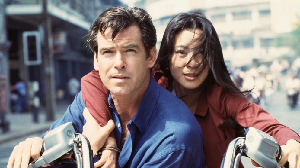 Irish actor Pierce Brosnan as 007 with Malaysian actress Michelle Yeoh as Wai Lin, on location in Thailand for the James Bond film 'Tomorrow Never Dies', 1997. Here they are handcuffed together for the motorcycle chase sequence. (Photo by Keith Hamshere/Getty Images) 