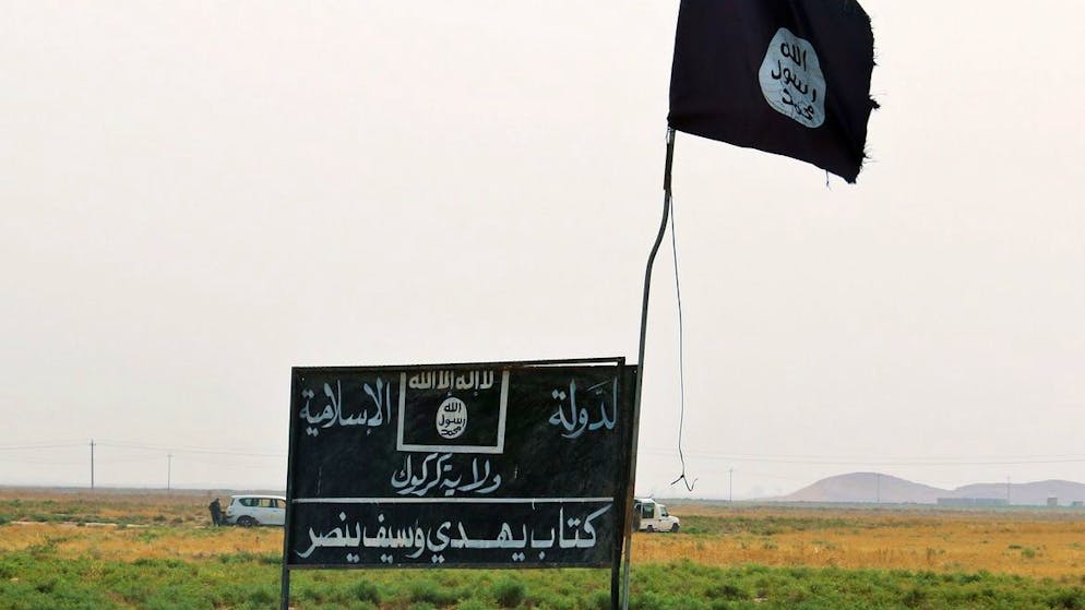 epa04925532 A flag and sign belonging to the group calling themselves the Islamic State (IS) sits on a roadside in territory liberated from the group during military operations south of Kirkuk, northern Iraq, 11 September 2015. According to a media reports Kurdish Peshmerga forces backed by airstrikes carried out by the international coalition claim to have recaptured four villages south of Kirkuk from the IS. EPA/STR