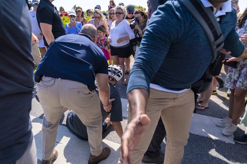 President Joe Biden is helped by Secret Service agents after falling from his bike as he stopped to greet a crowd on a trail at Gordons Pond in Rehoboth Beach, Del., Saturday, June 18, 2022. (AP Photo/Manuel Balce Ceneta)