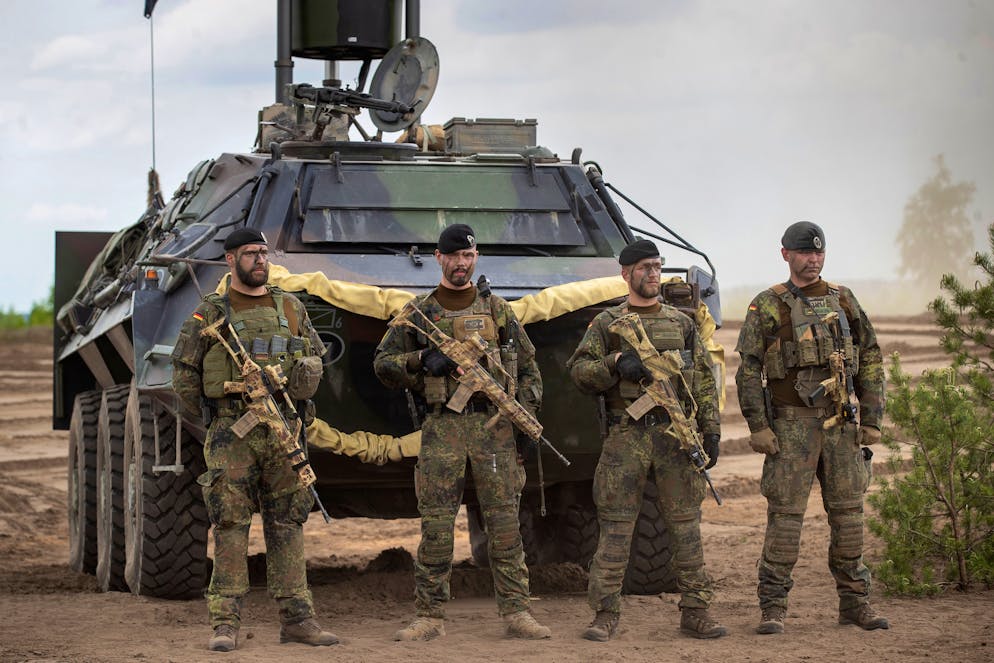 German Bundeswehr soldiers of the NATO enhanced forward presence battalion wait to greet German Chancellor Olaf Scholz upon his arrival at the Training Range in Pabrade, some 60km.(38 miles) north of the capital Vilnius, Lithuania, Tuesday, June 7, 2022.(AP Photo/Mindaugas Kulbis)