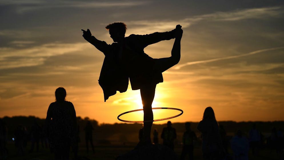 epa10024505 A reveller performs with a hoop as she attends summer solstice celebrations at the ancient Stonehenge monument in Wiltshire, Britain, 20 June 2022. Hundreds of people gathered at the 5,000-year-old stone circle, for the first time after two years of covid restrictions, to mark the longest day and shortest night in the northern hemisphere, which is due to fall on 21 June. EPA/NEIL HALL