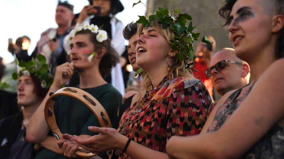 epa10024509 Revellers sing as they attend summer solstice celebrations at the ancient Stonehenge monument in Wiltshire, Britain, 20 June 2022. Hundreds of people gathered at the 5,000-year-old stone circle, for the first time after two years of covid restrictions, to mark the longest day and shortest night in the northern hemisphere, which is due to fall on 21 June. EPA/NEIL HALL
