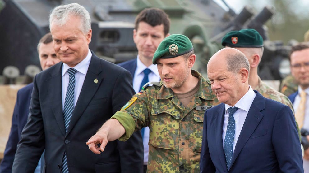 German Chancellor Olaf Scholz, right, and Lithuania's President Gitanas Nauseda, left, listen to Lieutenant Colonel Daniel Andra, the commander of the multi-national NATO Enhanced Forward Presence (EFP) battalion in Lithuania during a visit at the Training Range in Pabrade, some 60km (38 miles) north of the capital Vilnius, Lithuania, Tuesday, June 7, 2022. (AP Photo/Mindaugas Kulbis)