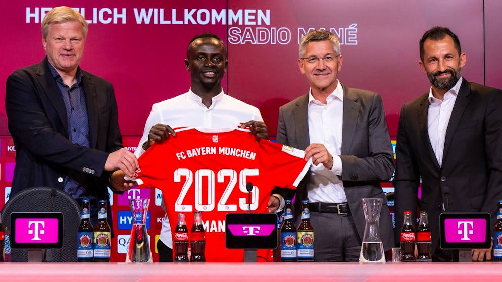 22.06.2022, Bayern, München: Fußball: Bundesliga, Vorstellung von Sadio Mane in der Allianz-Arena, Oliver Kahn (l-r), Vorstandsvorsitzender der FC Bayern München AG, Sadio Mane, Herbert Hainer, Präsident von München, und Hasan Salihamidzic, Sportdirektor von München, stehen nach der Vorstellung mit einem Trikot für ein Foto zusammen. Nach der Einigung mit dem FC Liverpool unterschrieb der 30-jährige Torjäger einen Dreijahresvertrag bis zum 30. Juni 2025 beim deutschen Fußball-Rekordmeister. Foto: Sven Hoppe/dpa +++ dpa-Bildfunk +++ (KEYSTONE/DPA/Sven Hoppe)