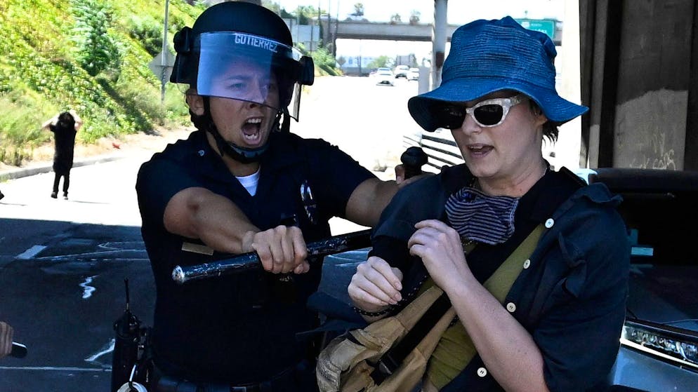 A Los Angeles Police Department officer pushes back an activist who attempted to walk onto the 110 Freeway at Broadway as demonstrators protested the U.S. Supreme Court's overturning of Roe v. Wade in Los Angeles, on Saturday, June 25, 2022. (Keith Birmingham/The Orange County Register via AP)