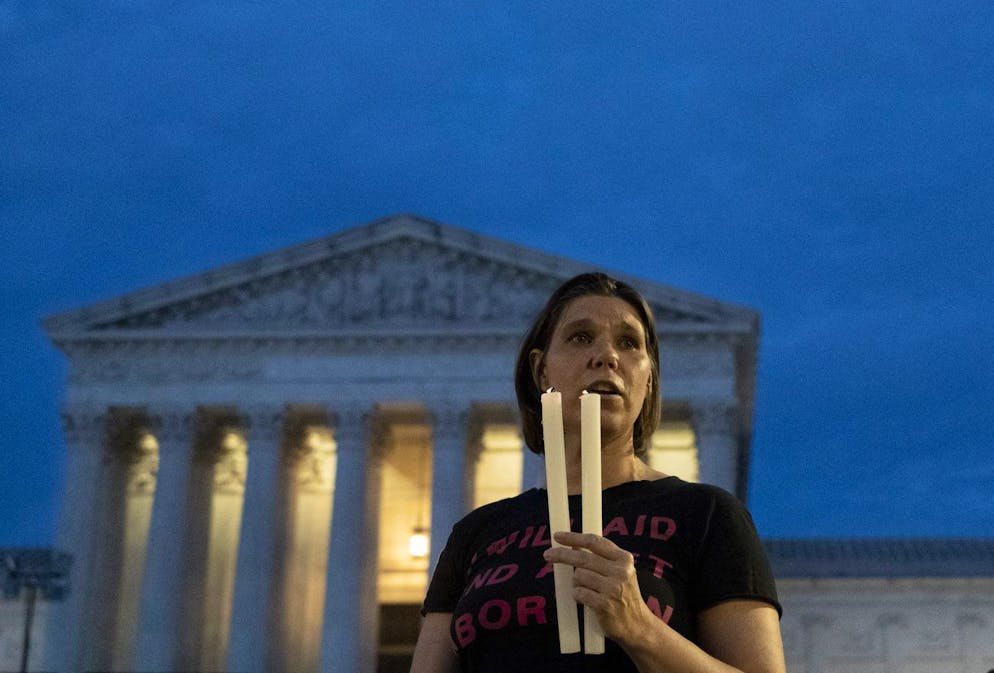 An abortion-rights protester holds candle during a candlelight vigil for reproductive freedom and abortion rights outside the Supreme Court in Washington, late Sunday, June 26, 2022. The Supreme Court has ended constitutional protections for abortion that had been in place nearly 50 years, a decision by its conservative majority to overturn the court's landmark abortion cases. (AP Photo/Gemunu Amarasinghe)