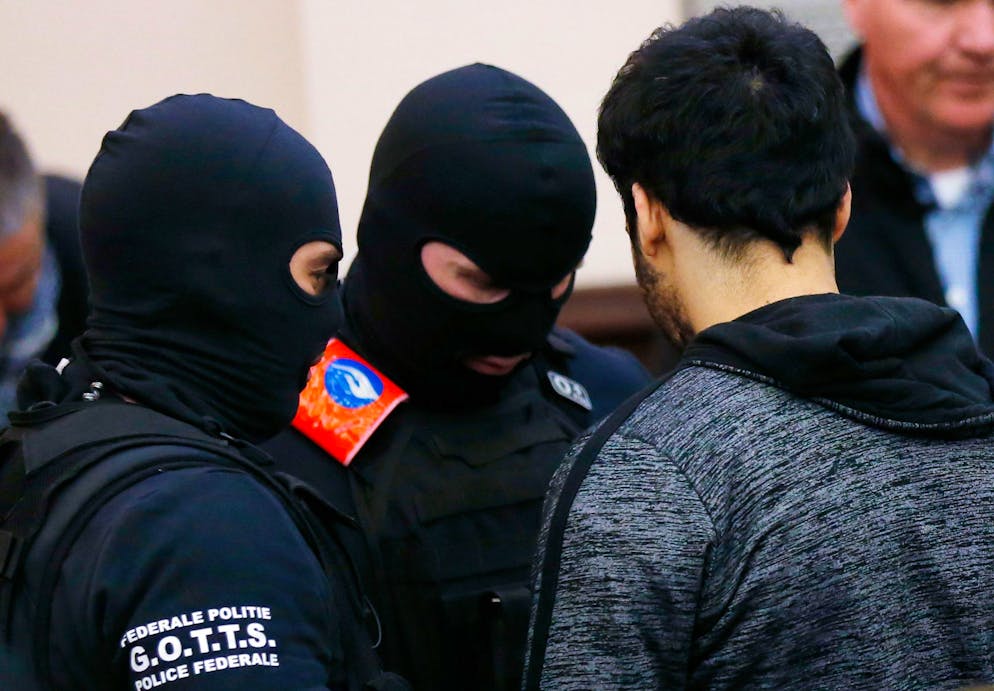 Alleged accomplice of the November 2015 Paris attacks suspect Salah Abdeslam, Sofiane Ayari (R), is escorted by Belgian police officers as he arrives in a courtroom on the second day of the trial of Salah Abdeslam and Sofiane Ayari at the