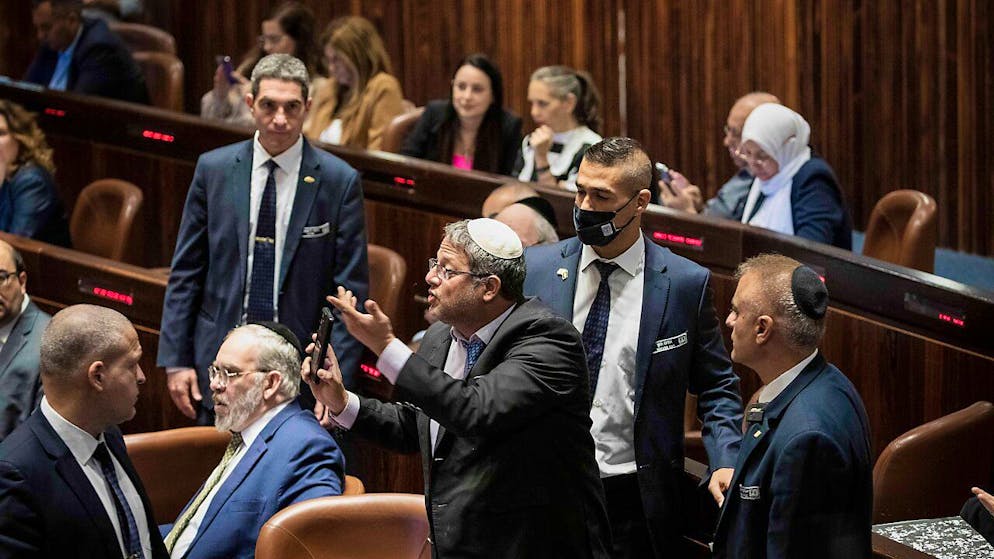 Itamar Ben-Gvir (M), Knessetmitglied, wird während der Abstimmung über die Auflösung der Regierung von Sicherheitskräften aus der Knessetanhörung eskortiert. Foto: Ilia Yefimovich/dpa
