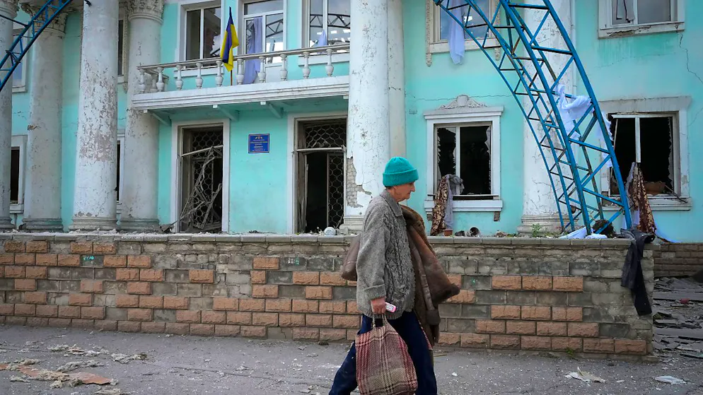 Eine Frau geht in der Nähe eines bei einem russischen Luftangriff zerstörten Gebäudes in Lyssytschansk vorbei. 
