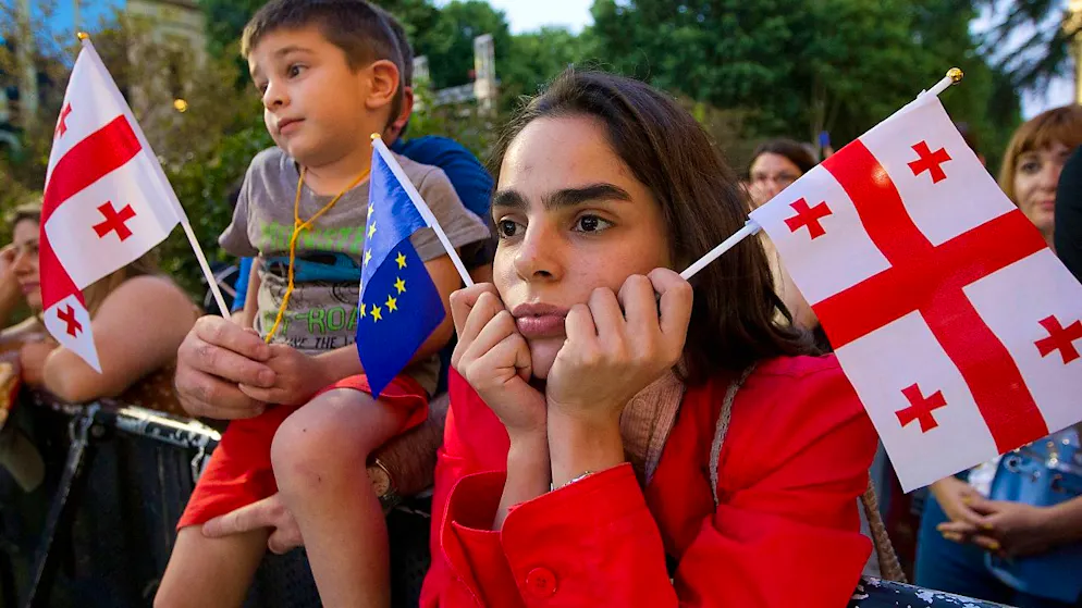 Eine Demonstrantin hält eine georgische Nationalflagge und eine EU-Flagge während einer Pro-EU- und Anti-Regierungs-Kundgebung vor dem georgischen Parlament. Foto: Shakh Aivazov/AP/dpa