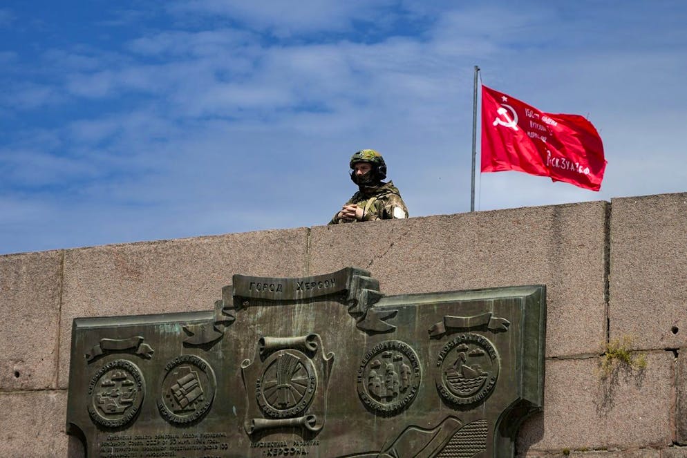 A Russian soldier guards an area at the Alley of Glory exploits of the heroes - natives of the Kherson region, who took part in the liberation of the region from the Nazi invaders, in Kherson, Kherson region, south Ukraine, Friday, May 20, 2022, with a replica of the Victory banner marking the 77th anniversary of the end of World War II right in the background. The Kherson region has been under control of the Russian forces since the early days of the Russian military action in Ukraine. This photo was taken during a trip organized by the Russian Ministry of Defense. (AP Photo)