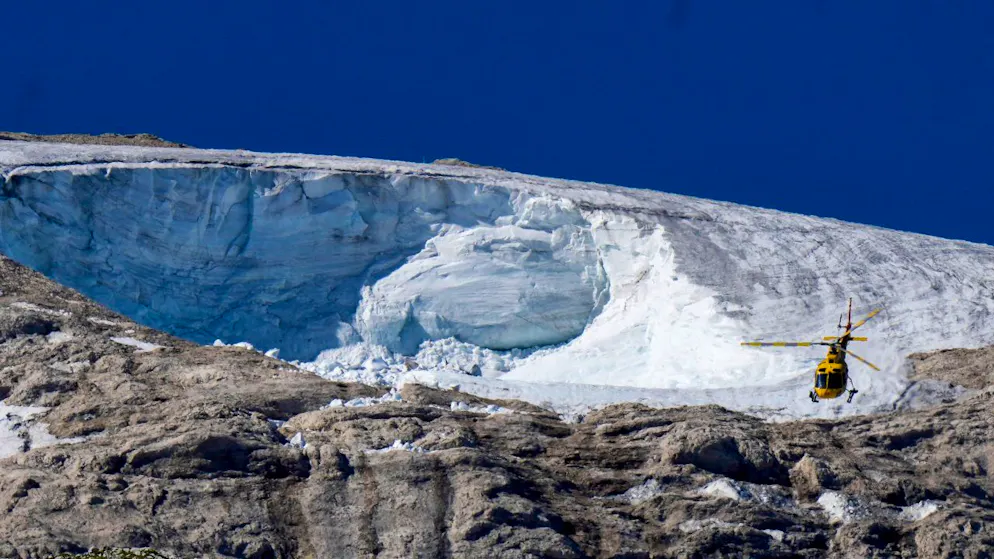 dpatopbilder - Ein Rettungshubschrauber fliegt am Mittwoch über den Punta-Rocca-Gletscher in den italienischen Alpen. Foto: Luca Bruno/AP/dpa