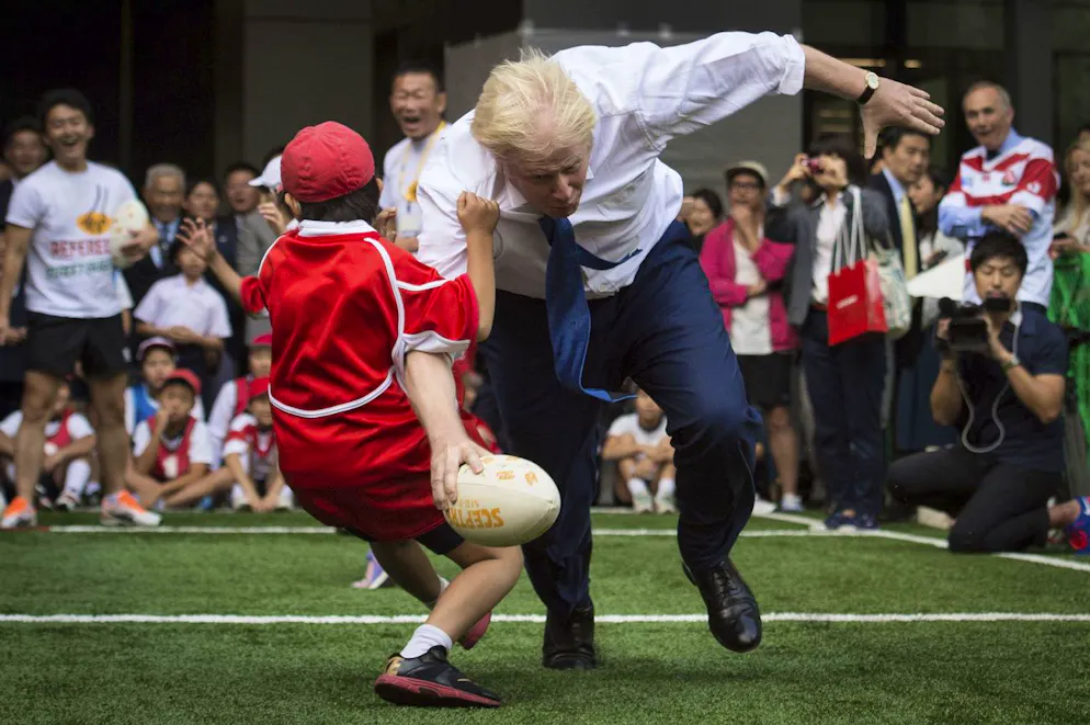Best of Boris Johnson. «Aus dem Weg»: Boris Johnson gibt vollen Einsatz bei einem Rugby Spiel im Jahr 2015 in Tokio. Aufhalten lässt er sich auch durch den Jungen nicht.