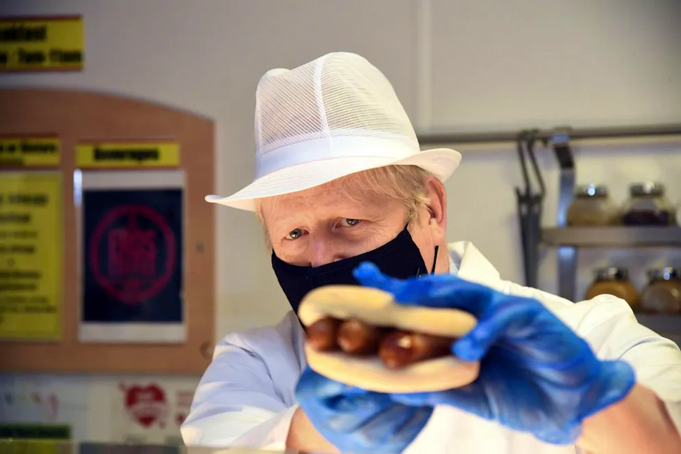 Best of Boris Johnson. Salzig statt süss: Boris Johnson mit einem Wurstbrötchen im Jahr 2020. 