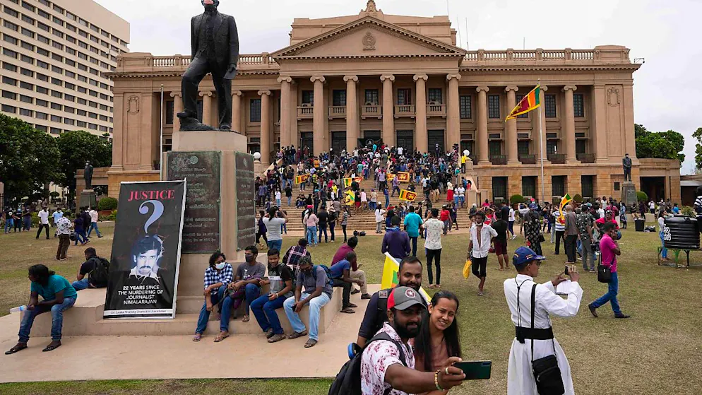 Einen Tag nach dem Sturm auf das Büro des Präsidenten gehen Demonstranten umher und halten sich auf dem Gelände auf. Nach den angekündigten Rücktritten des Präsidenten und des Premiers haben im krisengeschüttelten Sri Lanka mehrere Minister ihre Ämter aufgegeben. Foto: Eranga Jayawardena/AP/dpa