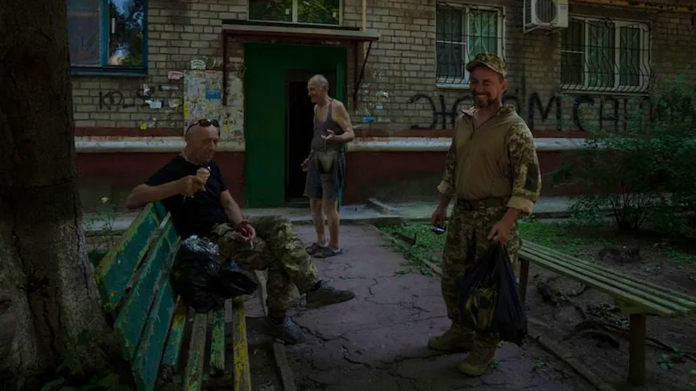 Der 70-jährige Witwer Walerij Iltschenko, zusammen mit Soldaten vor einem Wohnhaus in Kramatorsk. 