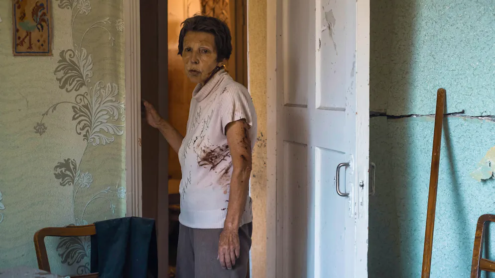 Eine Frau, die durch Glassplitter aus einem Fenster verletzt wurde, steht nach dem Beschuss eines Wohngebiets in der Stadt Kramatorsk am 7. Juli 2022 in ihrer Wohnung. 
