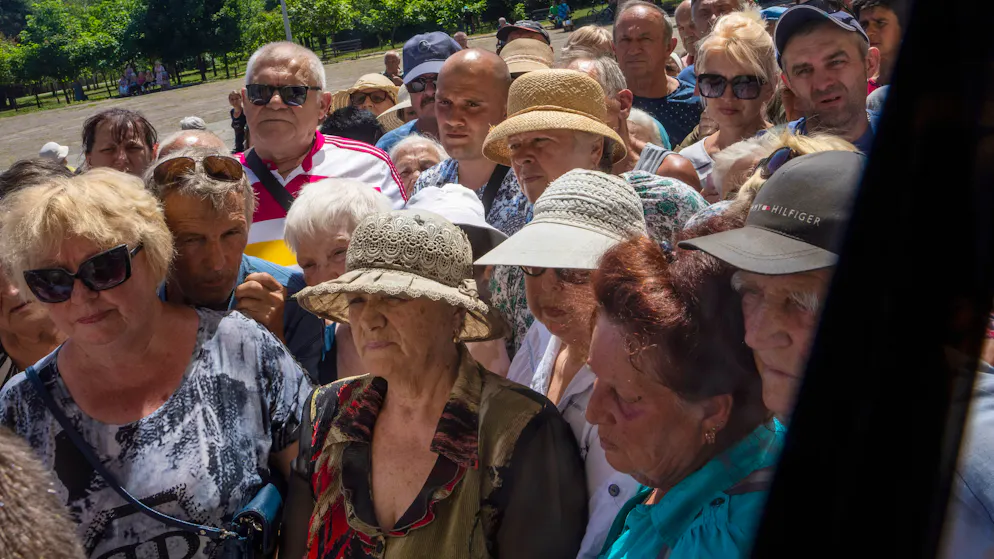 Menschen stehen Schlange, um humanitäre Nahrungsmittelhilfe vom Stadtrat von Kramatorsk in der Ostukraine zu erhalten.