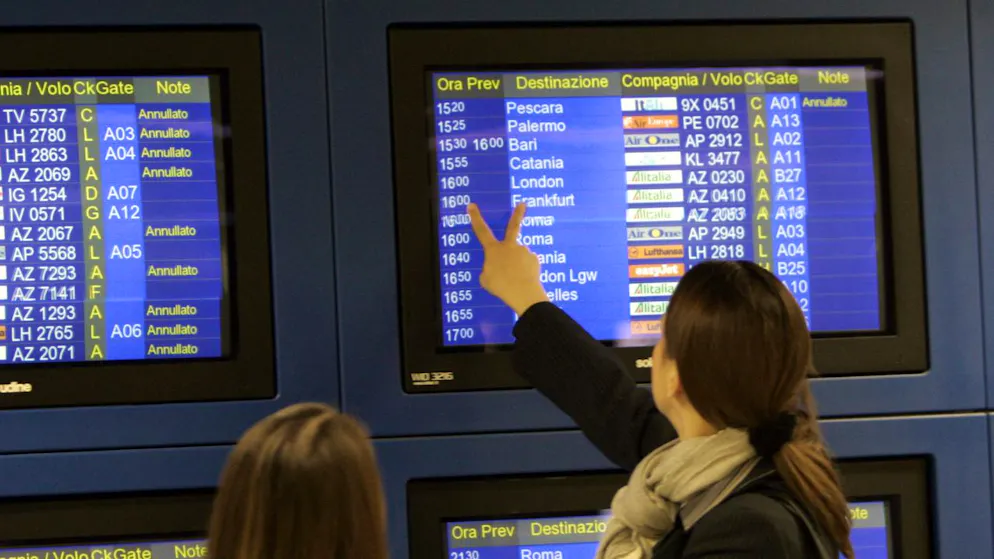 Zwei Frauen prüfen die Monitore mit den Abflugszeiten am Flughafen Linate in Mailand (I). (Archivbild)