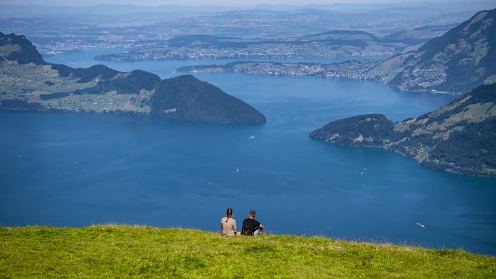 Zur Abkühlung empfiehlt sich diese Woche ein Ausflug in die Berge, wie es die Personen im Bild am Montag gemacht haben auf dem Niederbauen über dem Vierwaldstättersee. (KEYSTONE/Urs Flueeler)