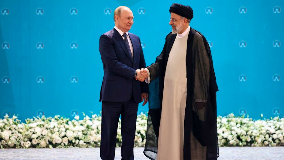 epa10080531 Russian President Vladimir Putin (L) shakes hands with Iranian President Ebrahim Raisi (R) during a trilateral summit on Syria in Tehran, Iran, 19 July 2022. The tripartite summit on Syria is held in the so-called Astana format and shall discuss the process in the conflict. EPA/SERGEI SAVOSTYANOV / KREMLIN POOL MANDATORY CREDIT