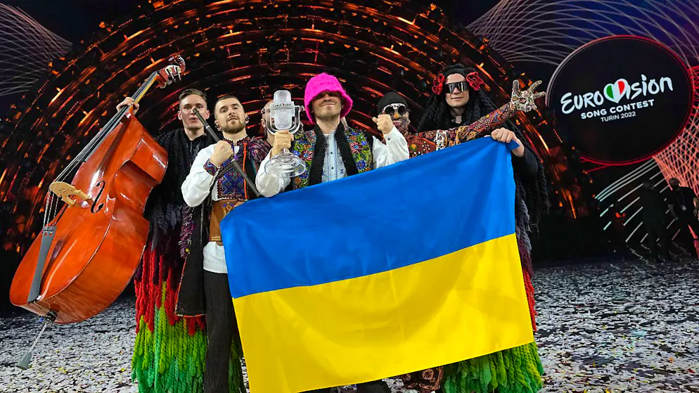 ARCHIV - Die Gruppe Kalush Orchestra aus der Ukraine jubelt über den Sieg des Eurovision Song Contest (ESC). Großbritannien wird im kommenden Jahr anstelle des diesjährigen Siegerlandes Ukraine den Eurovision Song Contest ausrichten. Foto: Luca Bruno/AP/dpa