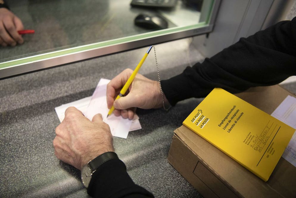 Ein Kunde tätigt seine Einzahlungen mittels Einzahlungsscheinen und Bestätigung dieser im Empfangsscheinbuch am Schalter. Ab Oktober werden nur noch Rechnungen mit QR-Code akzeptiert. (Gestellte Aufnahme)