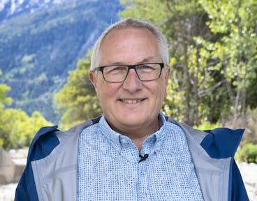 Thomas Wohlgemuth, initiateur du projet et co-auteur du livre guide de randonnee en Suisse permettant d'explorer a pied des sites de recherche pose avec son livre dans la foret de la reserve naturelle du Bois de Finges, au Parc naturel regional Pfyn-Finges mardi 18 mai 2021 a Salquenen. (KEYSTONE/Sandra Hildebrandt)