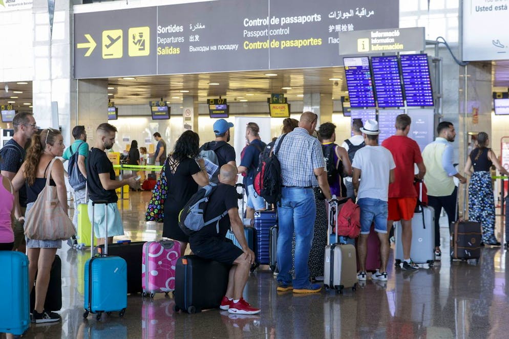 Diverse persone aspettano in coda davanti a un banco check-in al Terminal 2 dell'aeroporto di Barcellona-El Prat, in Spagna, EPA/Quique Garcà­a