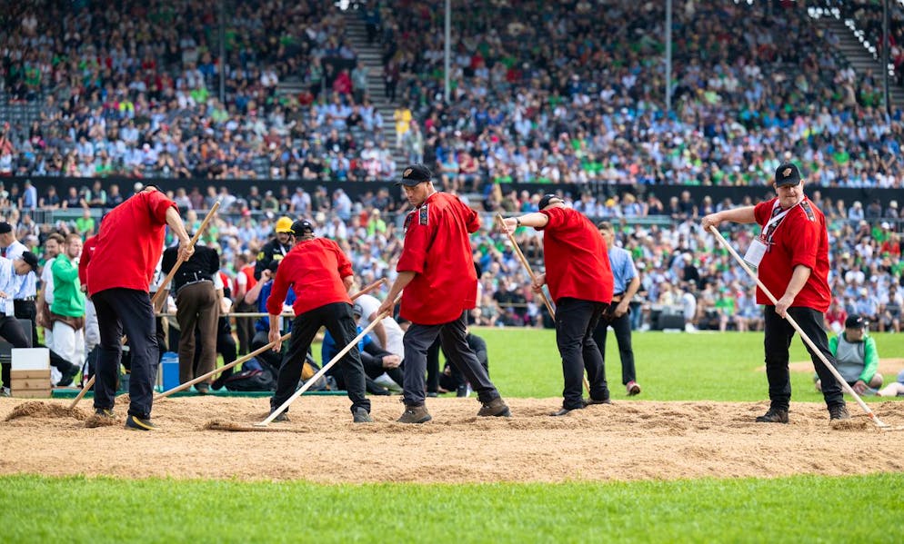 Die besten Bilder des Eidgenössischen. In der Zwischenzeit bearbeiten diese fleissigen Herren das Sägemehl mit Rechen.