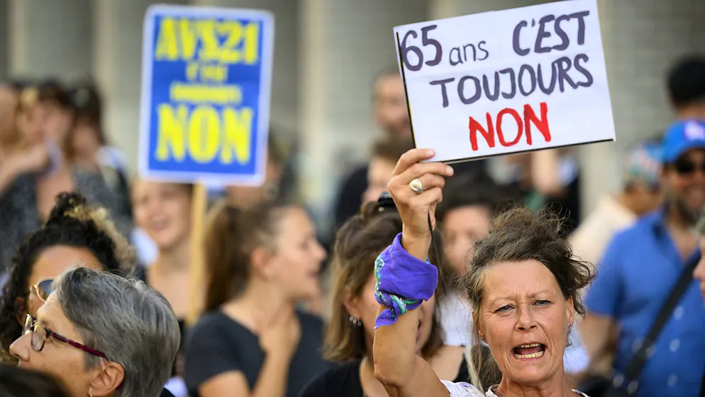 Une femme brandit une pancarte lors d'une manifestation contre la réforme de l'AVS à Lausanne. Les deux sondages publiés mercredi confirment le clivage entre les hommes et les femmes sur cet objet (archives).