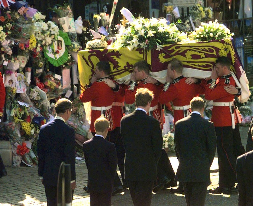 Lunghe file a Londra per Elisabetta. Nel 1997, 25 anni fa, aveva dovuto vivere delle scene simili, quando aveva detto addio alla madre Diana, morta in un incidente d&apos;auto a Parigi. Nella foto, la bara di Diana viene portata a&#xA0;Westminster Abbey, il 31 agosto del 1997. Da sinistra ci sono Carlo, Harry, Earl Spencer (il fratello di Diana) e William.