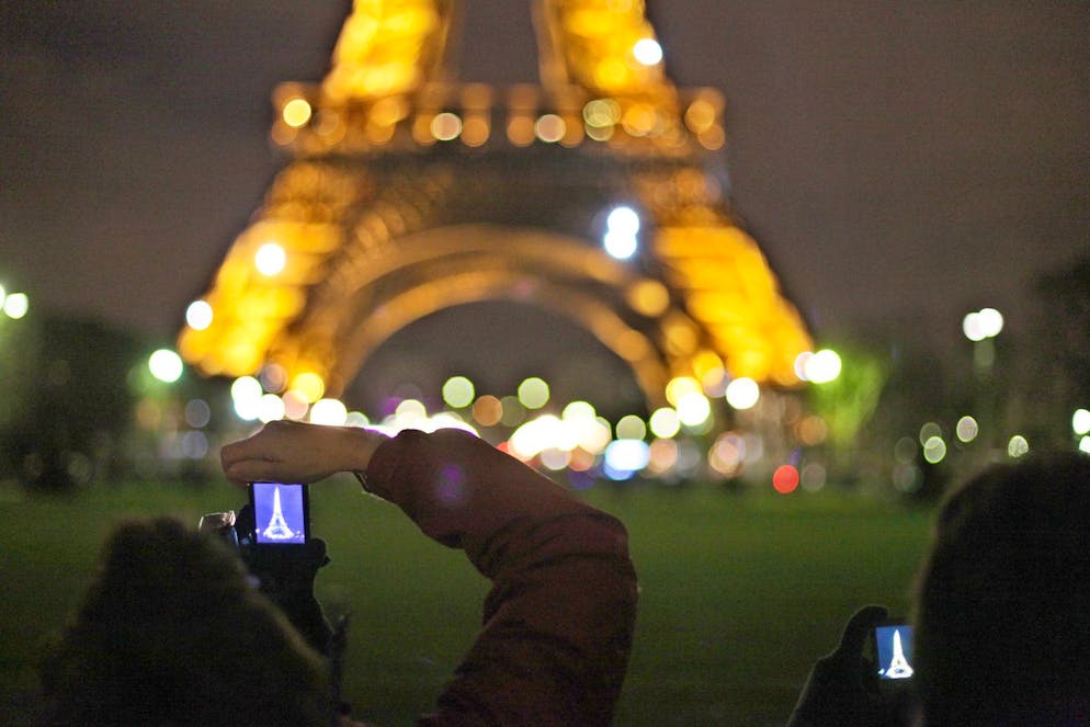A tourist takes picture of the Eiffel Tower, in Paris, Saturday, March 27, 2010, as the lights still illuminate the structure. Many millions of people worldwide are turning off lights and electrical appliances for one hour Saturday night, including those illuminating the Eiffel Tower, in a mass gesture to highlight environmental concerns and to call for a binding pact to cut greenhouse gas emissions. (AP Photo/Thibault Camus)