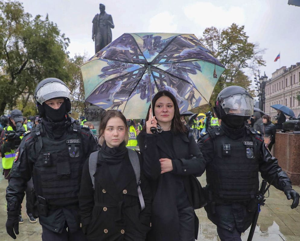 Zwei junge Frauen werden von Polizisten in Moskau abgeführt. Sie haben am 21. September an einer Protestaktion gegen Putins Krieg gegen die Ukraine teilgenommen.