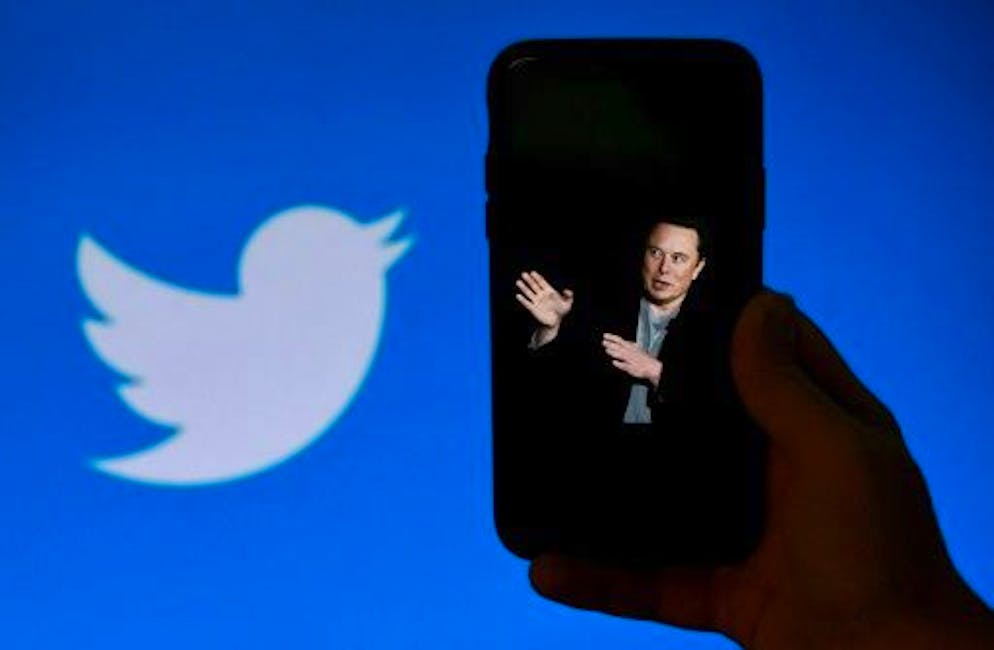 A phone with a photo of Elon Musk with the Twitter logo in the background, October 4, 2022, in Washington