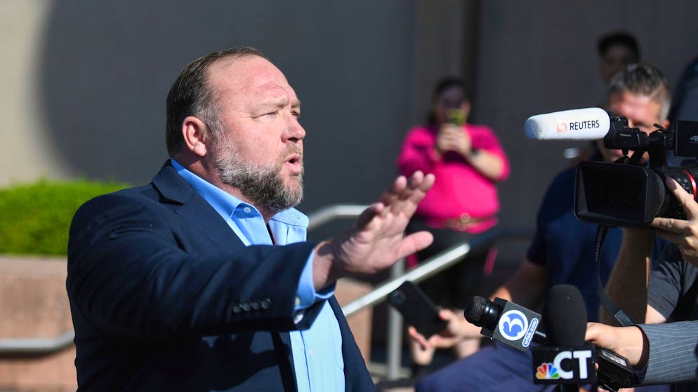 Alex Jones spricht zu Journalisten, bevor er das Gericht in Waterbury betritt.