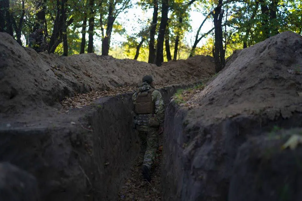 Un soldato ucraino esplora una trincea creata dalle truppe russe nella regione di Kherson prima di ritirarsi.