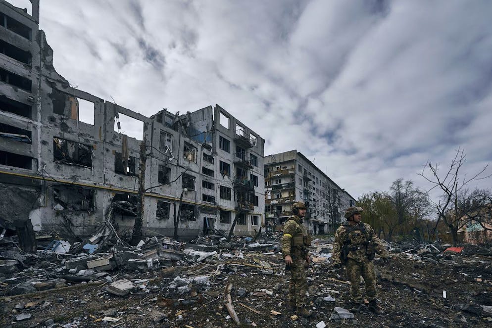 Soldati ucraini passano accanto alle case distrutte dai bombardamenti russi a Bachmut, nella regione di Donetsk, in Ucraina (foto d'archivio).