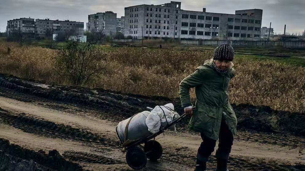 Una madre ucraina ha preso dell'acqua fresca a Bachmut il 10 novembre.