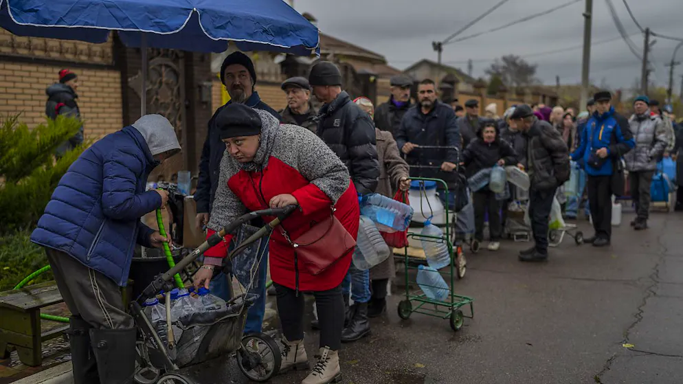 Residenti di Kherson, rimasti senza acqua ed elettricità, riempiono taniche di acqua potabile in strada (foto del 20 novembre 2022)