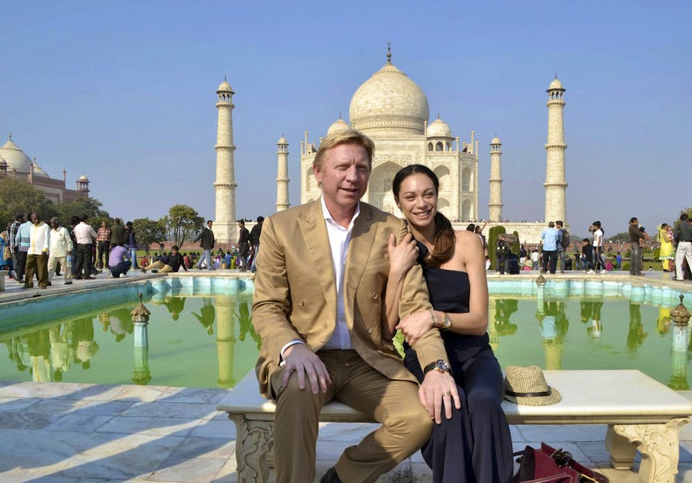 FILE - Former tennis star Boris Becker of Germany and his wife Lily pose for a photograph in front of the Taj Mahal in Agra, India, Sunday, Dec. 2, 2012. Becker is on a personal visit to India, according to local reports. Tennis great Boris Becker has been sentenced to 2 1/2 years in prison for illicitly transferring large amounts of money and hiding assets after he was declared bankrupt. The three-time Wimbledon champion was convicted earlier this month on four charges under the Insolvency Act and had faced a maximum sentence of seven years in prison. (AP Photo/Pawan Sharma, File)