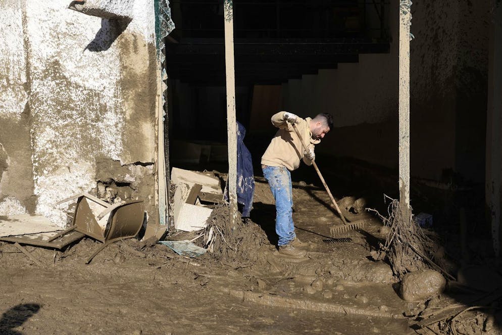 Un homme pelle de la boue après de fortes pluies a déclenché des glissements de terrain qui ont effondré des bâtiments et fait jusqu'à 12 personnes portées disparues, à Casamicciola.