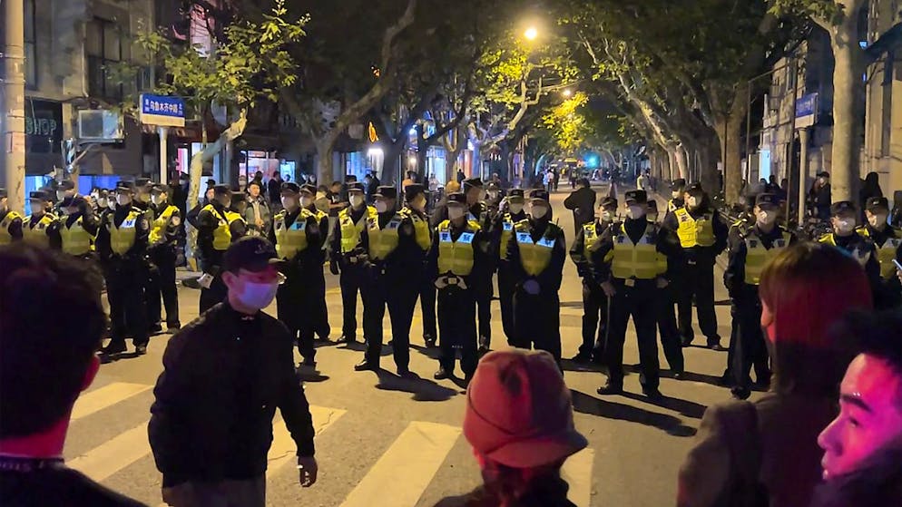 Polizia e dimostranti faccia a faccia a Shanghai.