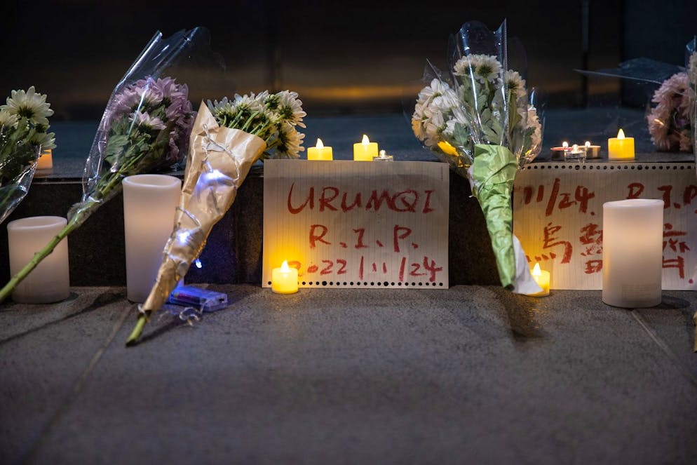 In Ürümqi liegen zahlreiche Blumen auf dem Boden. Hier starben zehn Personen bei einem Brand. Die Rettungskräfte sollen durch die strengen Corona-Massnahmen behindert worden sein.